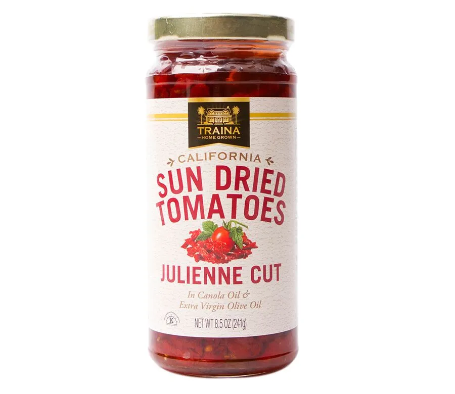Close-up of Traina® Home Grown California Sun Dried Tomatoes in Oil, Julienne Cut, showcasing our vibrant red tomatoes in a glass jar with twist cap. Dried under the California sun. We pack in oil seasoned with our special spice blend for a rich savory flavor. A perfect ingredient to enhance the flavor of pizza, pasta, sandwiches, and so much more.