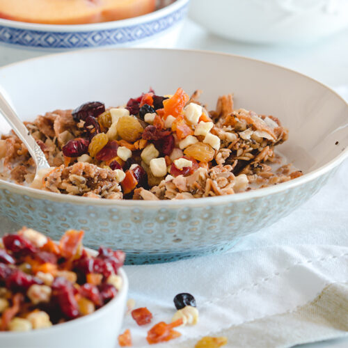 fruitons® All American Dried Fruit Blend as a topping on cereal or oatmeal, shown in a breakfast setting with a closeup of a cereal bowl.