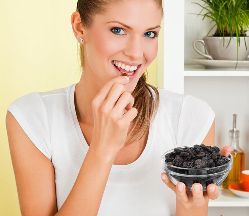 A woman eating Natural Sun Dried Natural Bing Pitted Cherries from Traina Home Grown.