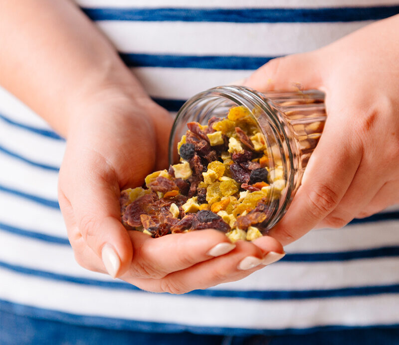 A glass jar filled with the All American Dried Fruit Blend from Traina Home Grown.